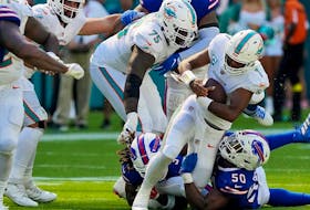 Tua Tagovailoa of the Miami Dolphins is sacked by Greg Rousseau of the Buffalo Bills during the fourth quarter at Hard Rock Stadium on September 25, 2022 in Miami Gardens, Florida.