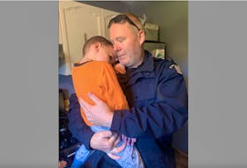 Grady MacKinnon gets a hug from one of the RCMP officers who had responded to the call of a missing child. The officer, like other searchers was happy to see the boy safe.
