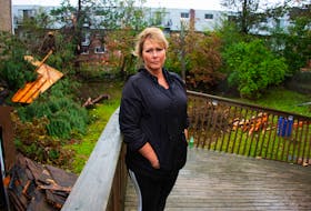 Jennifer Bathurst poses for a photo on her damaged deck at her Spryfield home on Tuesday, Sept. 26, 2022. High winds from post-tropical storm Fiona ripped off the roof of an apartment building behind her home causing significant damage to her house and yard, as well as nearby cars and homes.
Ryan Taplin - The Chronicle Herald