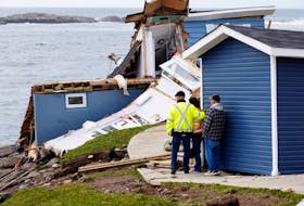 Port aux Basques Mayor Brian Button speaks with two people whose house was damaged after the arrival of hurricane Fiona in Port Aux Basques. — REUTERS