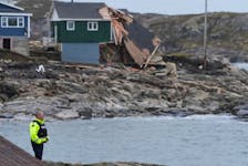 An RCMP officer overlooks the devastation from hurricane Fiona in Port aux Basques.
