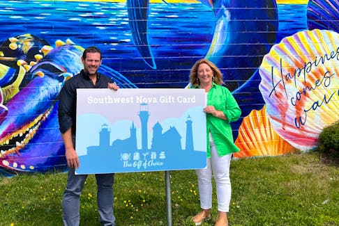 Standing in front of a mural on Yarmouth’s Water Street painted by Danielle Mahood; Krista Smith, owner of The Style Merchant, and Jason Murphy, co-owner of Heritage Brewing Company, stand with an enlarged promo version of the Southwest Nova Gift Card – a new Chamber initiative. CONTRIBUTED