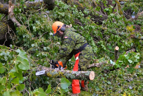 Pte. Emma Bowman, a medic with the 33 Field Ambulance, was responsible for cutting up a large cluster of trees on Sept. 27 that fell behind Birchwood Intermediate School on Longworth Avenue in Charlottetown. Bowman was one of 34 soldiers tasked with helping with cleanup efforts from post-tropical storm Fiona. TERRENCE MCEACHERN • THE GUARDIAN
