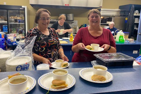 There was plenty of comfort, including hot food and beverages, inside the Louisbourg Volunteer Fire Department's Joseph Trimm Community Centre on Tuesday. The hall is being used as an emergency comfort centre. Above, volunteers Mary Marsdon, left, and Gail Bond prepare to hand out some hot soup, while Jeannie Pearl and Sharon Carter work in the background. DAVID JALA/CAPE BRETON POST