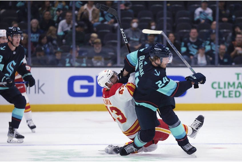  Seattle Kraken defenceman Jamie Oleksiak and Calgary Flames forward Adam Klapka become entangled during the first period of a preseason NHL hockey game Tuesday night in Seattle.