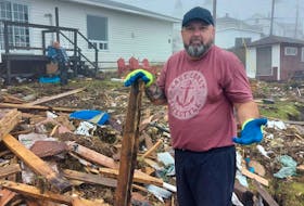 Port aux Basques realtor Scott Strickland stands among the debris left by post-tropical storm Fiona in his Port aux Basques yard. Strickland says the storm is having a devastating effect on housing in the town. - Contributed