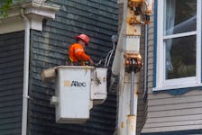 A electrician works on a service line on the side of a house on Carlton Street in Halifax on Wednesday, Sept. 28, 2022. 
Ryan Taplin - The Chronicle Herald