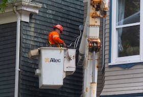 A electrician works on a service line on the side of a house on Carlton Street in Halifax on Wednesday, Sept. 28, 2022. 
Ryan Taplin - The Chronicle Herald