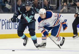 Seattle Kraken forward Alex Wennberg and Edmonton Oilers forward Reid Schaefer battle for the puck during the first period of a preseason NHL hockey game, Monday, Sept. 26, 2022, in Seattle.