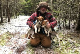 Bob Wakeham is pictured with Molly and Tibbs, two beagles that spent a cold and lonely night in the woods last February after Molly became trapped in a rabbit snare. - Contributed