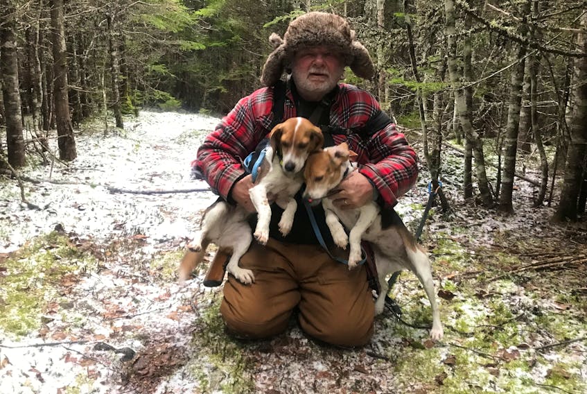 Bob Wakeham is pictured with Molly and Tibbs, two beagles that spent a cold and lonely night in the woods last February after Molly became trapped in a rabbit snare. - Contributed