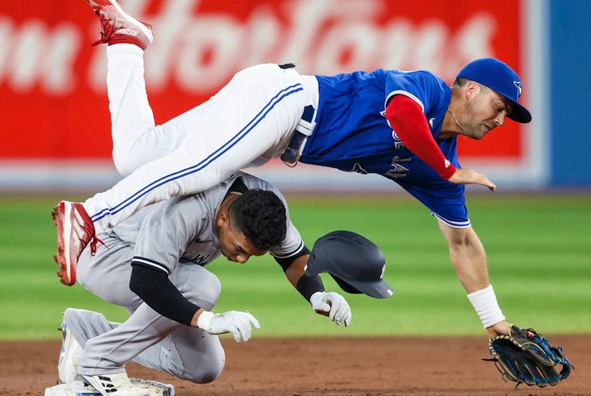Oswald Peraza of the New York Yankees collides with Whit Merrifield of the Toronto Blue Jays at second base at Rogers Centre on September 28, 2022 in Toronto.