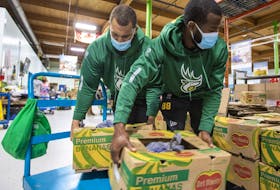 Edmonton Elks Jaylan Guthrie and Lucky Jackson, this year’s Purolator Tackle Hunger team ambassadors, lend a hand during a visit to Edmonton's Food Bank on Thursday, Sept. 22, 2022. Donations of cash and non-perishable food items will be accepted during Saturday's game at Commonwealth Stadium.
