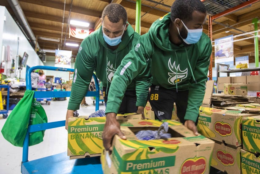 Edmonton Elks Jaylan Guthrie and Lucky Jackson, this year’s Purolator Tackle Hunger team ambassadors, lend a hand during a visit to Edmonton's Food Bank on Thursday, Sept. 22, 2022. Donations of cash and non-perishable food items will be accepted during Saturday's game at Commonwealth Stadium.
