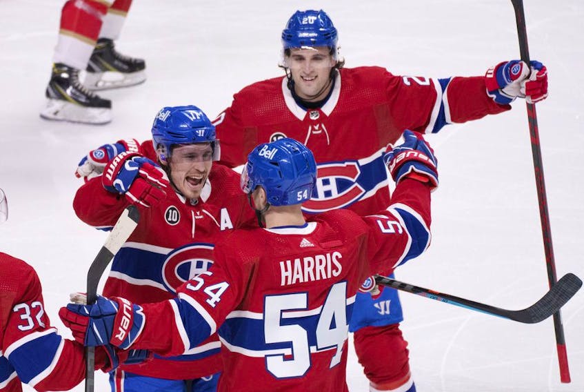 Montreal Canadiens' Brendan Gallagher, left, and Chris Wideman, top, congratulate teammate Jordan Harris after scoring against Florida Panthers during first period in Montreal on April 29, 2022.