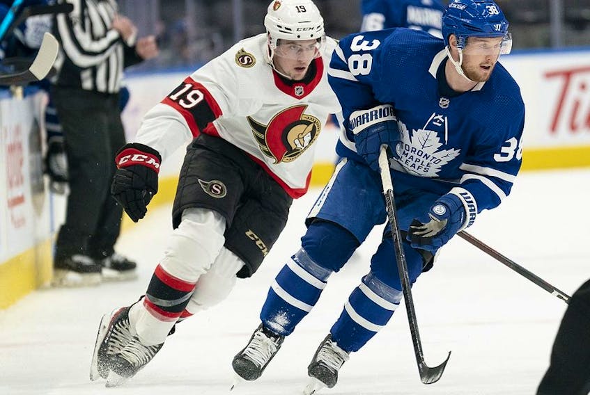 Jan 1, 2022; Toronto, Ontario, CAN; Toronto Maple Leafs defenseman Rasmus Sandin skates with the puck as Ottawa Senators right wing Drake Batherson gives chase during the second period at Scotiabank Arena. 