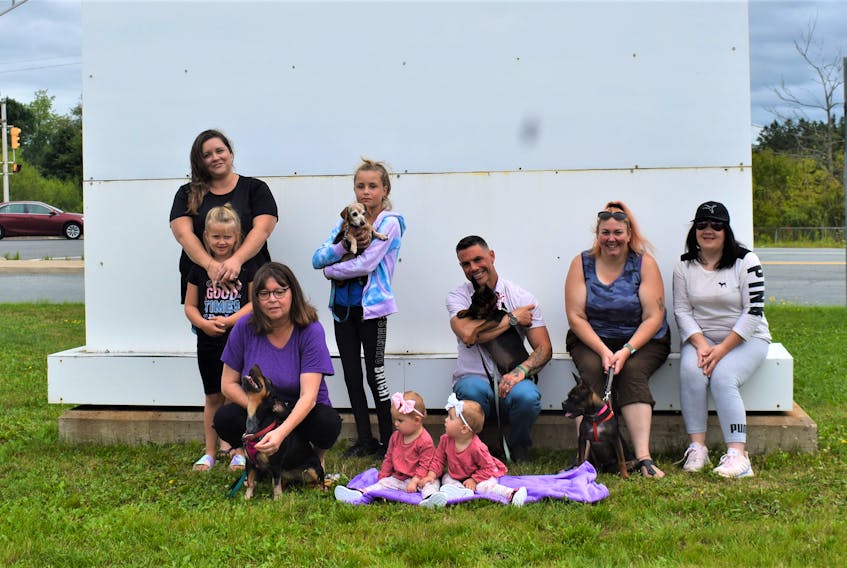 Members of Wee Ones Dog Rescue group and their family members, both human and canine, gather in the section of the Rath Eastlink Community Centre parking lot which will host DogFest Sept. 10. Pictured are Jacqueline Thompson (left) with arms around Addilyn Thompson, Harmoni Thompson, Paul Downey, Sonia Swindells, Rebecca Cox, Cindy Harrison (left, kneeling) and twins Kibo and Elsa Nelson.  
 
 Richard MacKenzie