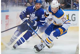 Owen Power of the Buffalo Sabres playing in his first career NHL game battles against Alexander Kerfoot of the Toronto Maple Leafs at Scotiabank Arena on April 12, 2022 in Toronto, Ontario, Canada.