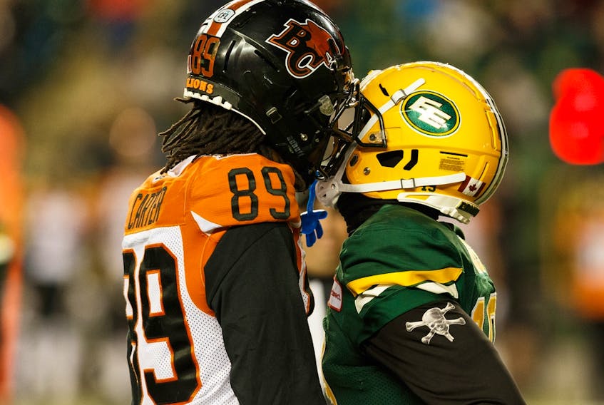 Former Edmonton Elks defensive back Tyquwan Glass (19) shares words with former B.C. Lions receiver Duron Carter (89) during Edmonton's last home win at Commonwealth Stadium on Oct. 12, 2019.