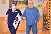 Cedarstone resident Bill Davis completing his Terry Fox Walk laps with the help of staff member Jonita King.