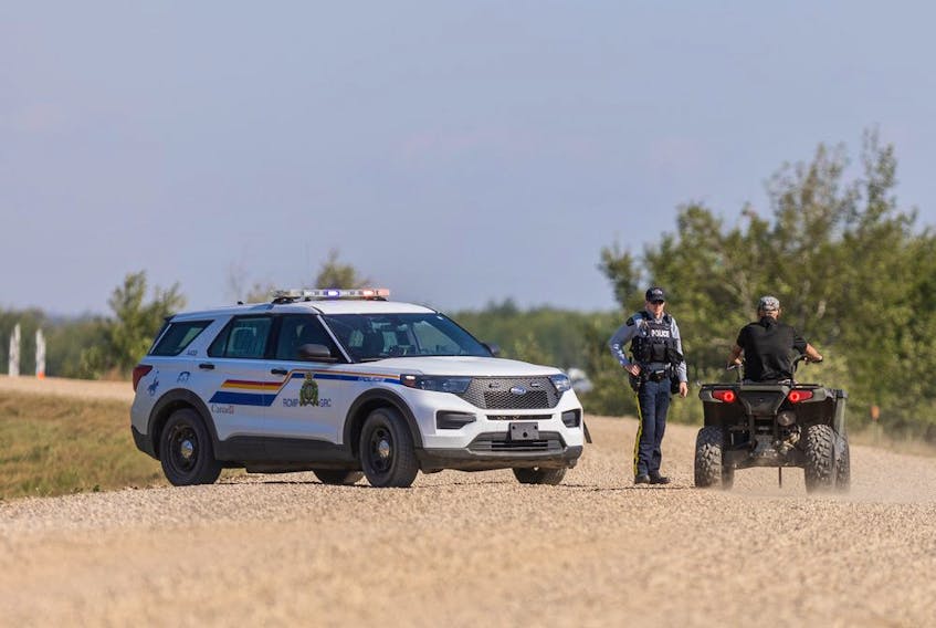 An RCMP officer talks with a resident on James Smith Cree Nation after reports of a possible sighting of Myles Sanderson on the reserve. Photo taken in James Smith Cree Nation, SK on Tuesday, September 6, 2022.