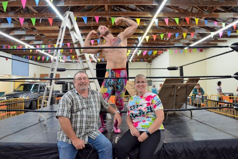 With a ladder and broken table still in the ring, Cogmagun, Hants County native Cody Brown, a.k.a. Lil’ Blay, celebrates his Aug. 27 tables match victory over Kato with his parents, Adam and Torra Brown, in the industrial building at the Windsor Exhibition Grounds. KIRK STARRATT