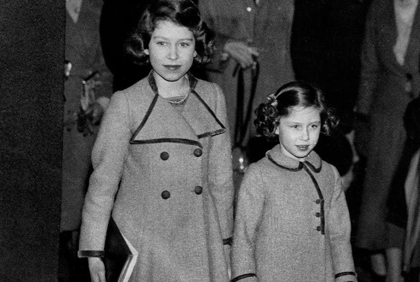 Picture taken on March 12, 1937 showing Princesses Elizabeth (L)and Margaret leaving the Royal Agricultural Hall after watching the competitions at the Pony Show. (Photo by - / CENTRAL PRESS PHOTO LTD / AFP) (Photo by -/CENTRAL PRESS PHOTO LTD/AFP via Getty Images)