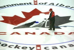 Ice Technician Ryan Smith (with hose) and Blayne Sproule prepare the ice over top of a Team Canada logo on the Calgary Flames locker room on Aug 21/ 09 as Hockey Canada prepares to take over the Pengrowth Saddledome for the team Canada Olympic Camp next week. 