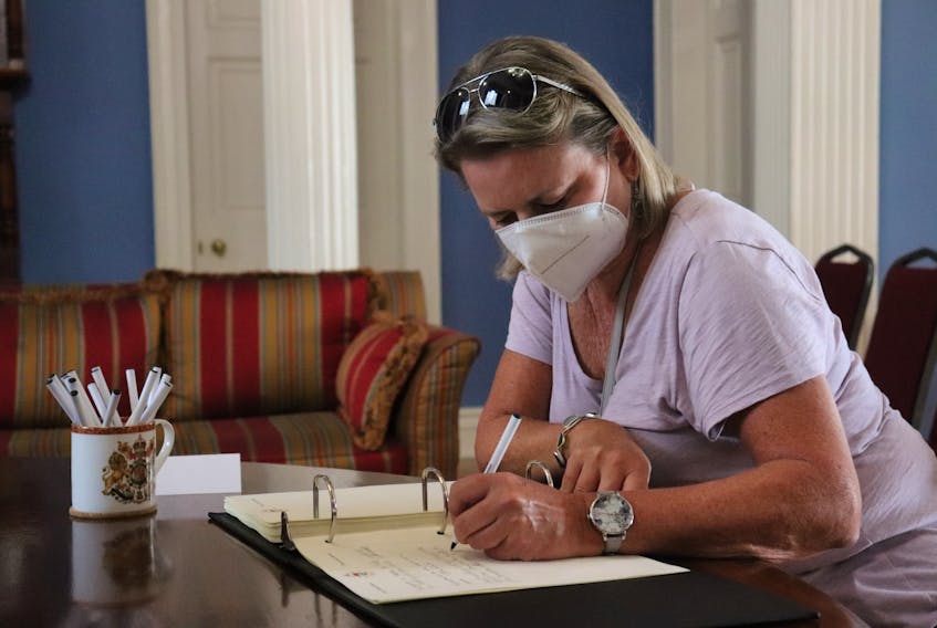 Tracey Laughlin, a Summerside resident, signs the book of condolence for the Queen’s family at Government House in Charlottetown. She says it felt like her duty to honour a leader who emphasized duty. Logan MacLean • The Guardian