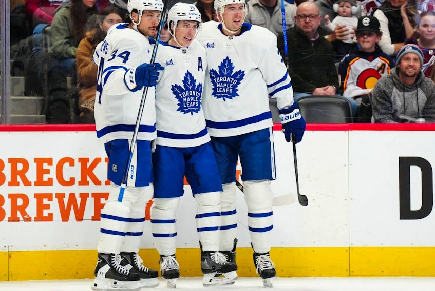 Toronto Maple Leafs right wing Mitch Marner (16) celebrates with centre Auston Matthews (34) and defenceman Justin Holl (3) after scoring a goal against the Colorado Avalanche.