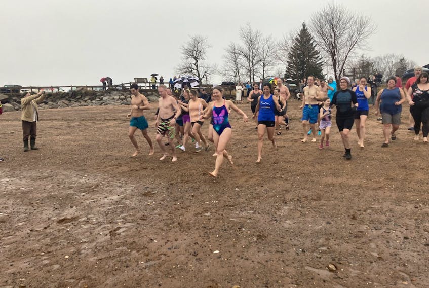 Participants in the Polar Bear Dip in Kingsport head for the waters of the Minas Basin Sunday. - Ian Fairclough