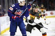  Lane Hutson (20) of Team USA is checked by Luca Hauf (17) of Team Germany in their quarter-final game at the 2023 IIHF world junior championships at Avenir Centre on Jan, 2, 2023, in Moncton, N.B.