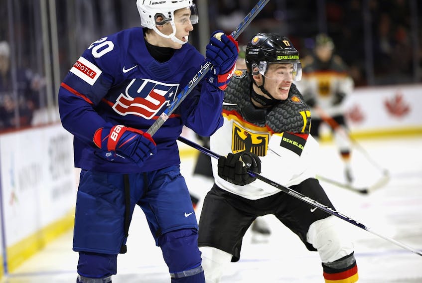  Lane Hutson (20) of Team USA is checked by Luca Hauf (17) of Team Germany in their quarter-final game at the 2023 IIHF world junior championships at Avenir Centre on Jan, 2, 2023, in Moncton, N.B.