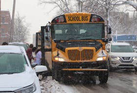 A public school bus picks up a group of children at Murphy's Pharmacies Community Centre in Charlottetown on Jan. 10. The diesel buses will be phased out over the next five years at the cost of $51 million and will be replaced by electric buses. Rafe Wright • The Guardian
