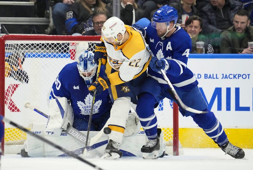 Maple Leafs' Morgan Rielly (right) tries to clear Nashville Predators' Nino Niederreiter from out in front of Leafs goaltender Matt Murray during the second period in Toronto on Wednesday, Jan. 11, 2023. 