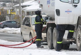Irving employees completing a fuel delivery at a home in St. John's.