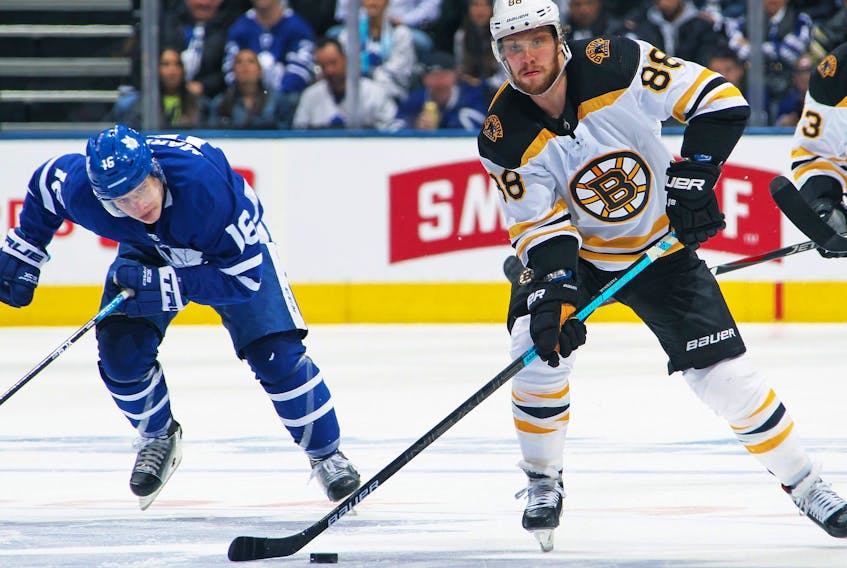 David Pastrnak of the Boston Bruins makes a pass ahead of Mitchell Marner of the Toronto Maple Leafs in Game Three of the Eastern Conference First Round during the 2019 NHL Stanley Cup Playoffs at Scotiabank Arena on April 15, 2019 in Toronto, Ontario, Canada.  