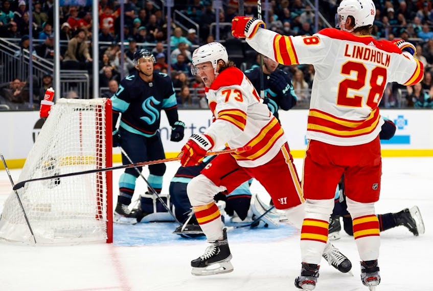 Calgary Flames forward Tyler Toffoli celebrates a goal, along with linemate Elias Lindholm, against the Seattle Kraken at Climate Pledge Arena in Seattle on Dec. 28, 2022.