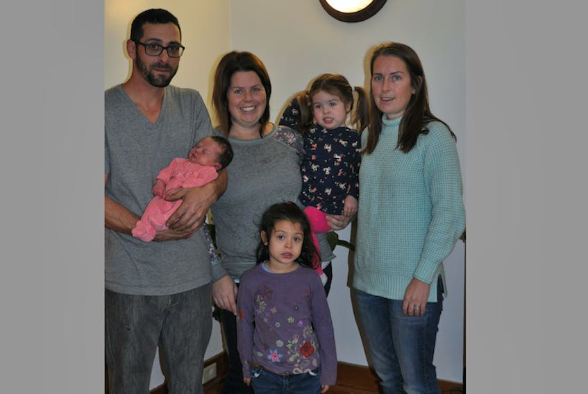 Jimmy Hebert and Sarah Martin with their three children: Stella (4), Annie (2) and newborn Claire France. Martin delivered Claire at home with the help of Hebert and her sister Katherine Nolter (right).