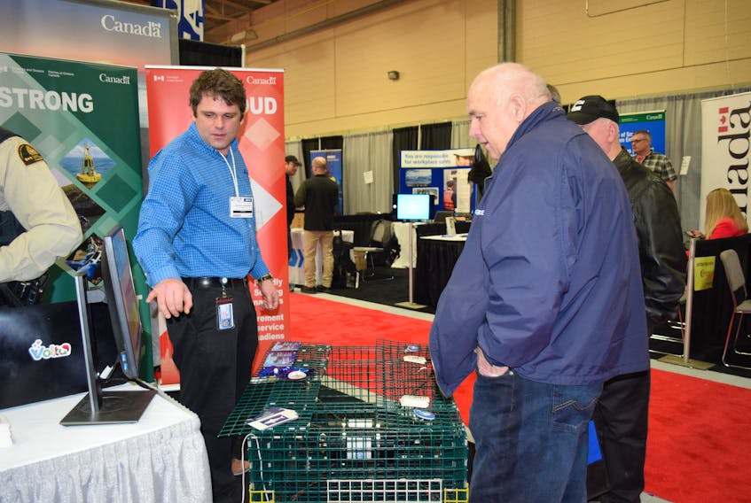 Jonathan Underwood (left), Oceans and Ecosystems Officer with DFO in Yarmouth, talks with people at the  2019 Eastern Canadian Fisheries Exposition in Yarmouth about a hydrophone  project. KATHY JOHNSON