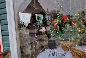A Thoms Flowers employee cleans up broken glass at the Glace Bay flower shop after vandals smashed windows on Friday night. There are reports of multiple homes, properties and businesses that have suffered damage that night. CONTRIBUTED