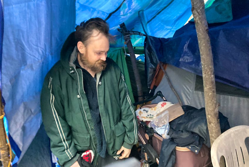 Daniel Hovey steps out of his tent Monday morning. He has been living at the homeless encampment bordering Flinn Park in Halifax since late last summer.