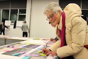 Charlottetown resident Barbara Dylla fills out a post-it with feedback to stick on the design images for revitalizing Province House Historic District. George Melitides • The Guardian