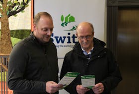 Energy management engineer Nick Walker, left, observes a pamphlet for the Charlottetown Switch program with Charlottetown chair of environment and sustainability Terry Bernard at city hall on Jan. 19. Rafe Wright • The Guardian
