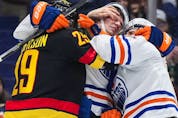  Vancouver Canucks’ Lane Pederson, left, gets into a scuffle with Edmonton Oilers’ Klim Kostin, centre, and Dylan Holloway during the first period of an NHL hockey game in Vancouver, on Saturday, January 21, 2023.