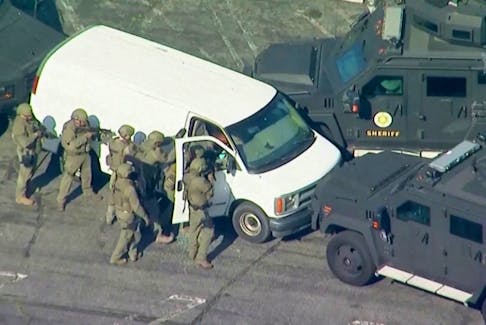 Police use armoured vehicles to surround a white cargo van where they later find the Monterey Park mass shooting suspect dead as a SWAT team approaches at a parking lot in Torrance, Calif., Jan. 22, 2023 in a still image from video. - ABC Affiliate KABC via Reuters