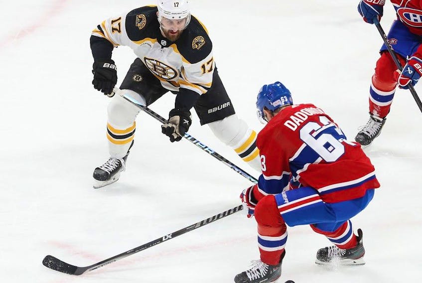 Montreal Canadiens' Evgenii Dadonov (63) looks back at the puck with Boston Bruins' Nick Foligno (17) comes into the play during first period NHL action in Montreal on Tuesday January 24, 2023.