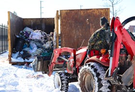 A tractor takes belongings to a dumpster at the Charlottetown Event Grounds on Jan. 25. A homeless encampment had been set up there since September. Logan MacLean • The Guardian