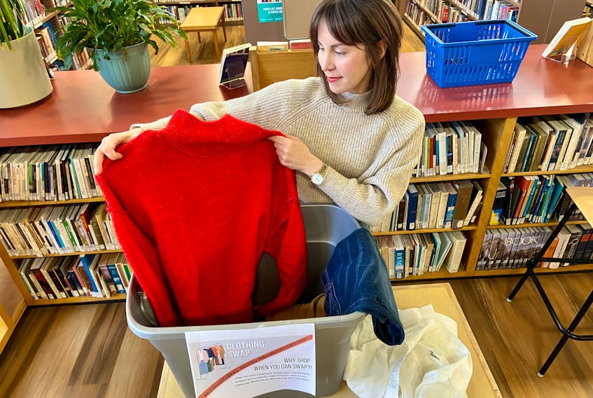 Jannette Vusich holds up an item of clothing dropped off as part of a clothing swap being hosted by the James McConnell Memorial Library, the Sydney branch of the Cape Breton Regional Library. CONTRIBUTED
