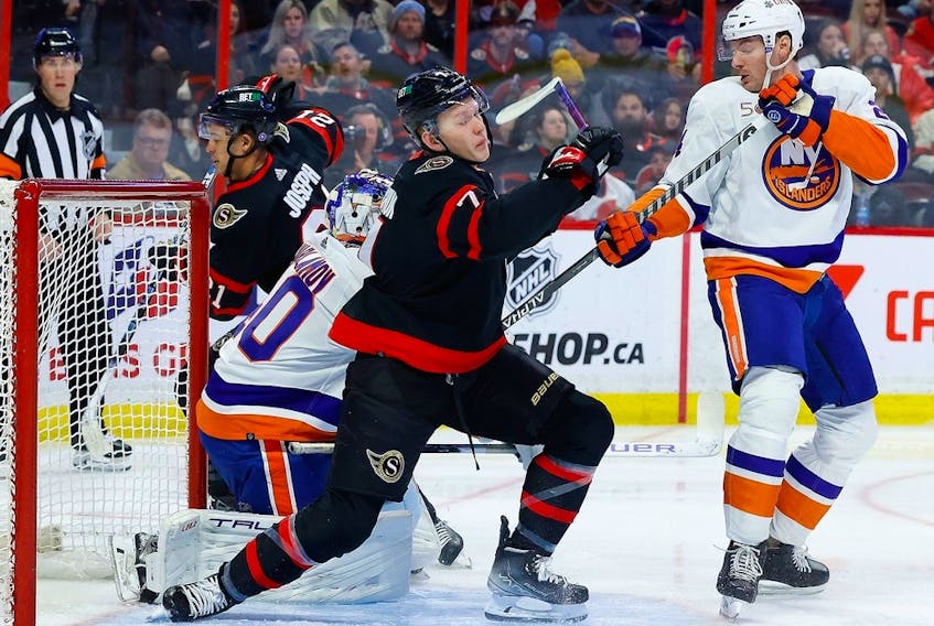  Ottawa Senators left wing Brady Tkachuk gets tangled up with New York Islanders defenceman Scott Mayfield during the first period at the Canadian Tire Centre on Wednesday, Jan. 25, 2023.
